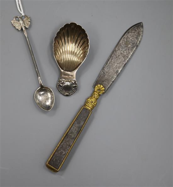 A silver shell caddy spoon, a Ceylonese white metal spoon and a 19th century steel and ormolu letter opener